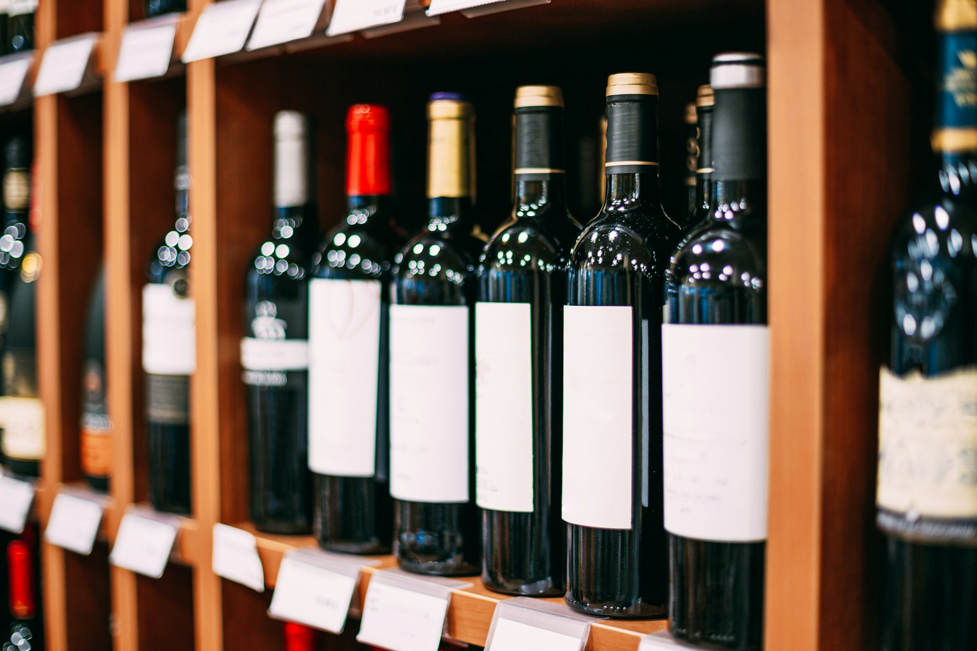 Showcase With Wine Bottles At Wine Store. Wall With Alcoholic Drinks Wine Bottles On Shelves